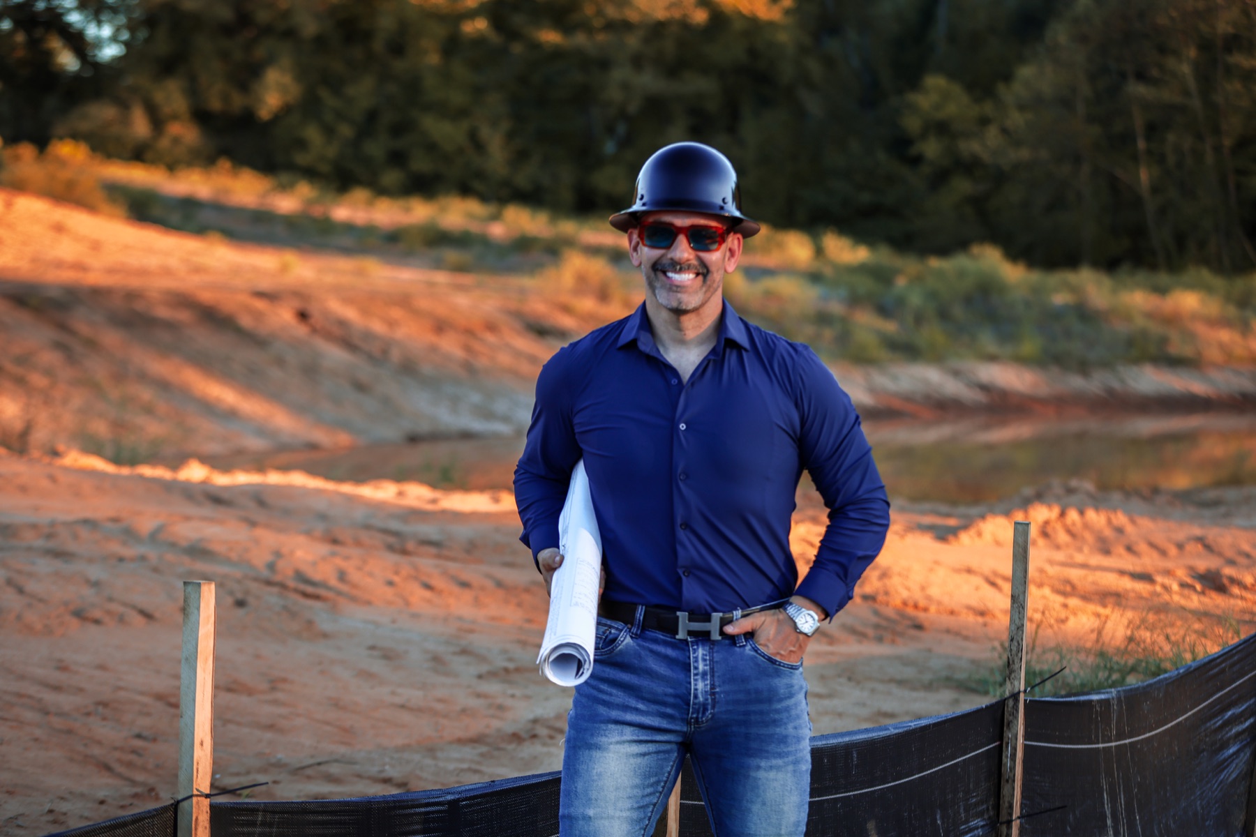 Irving Ravelo en terreno de desarrollo con planos de construcción